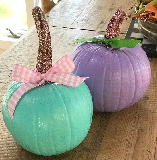 Purple and teal painted pumpkins with glittered stems