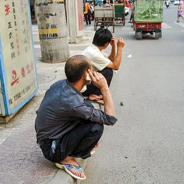 Men sitting on their haunches in Asia