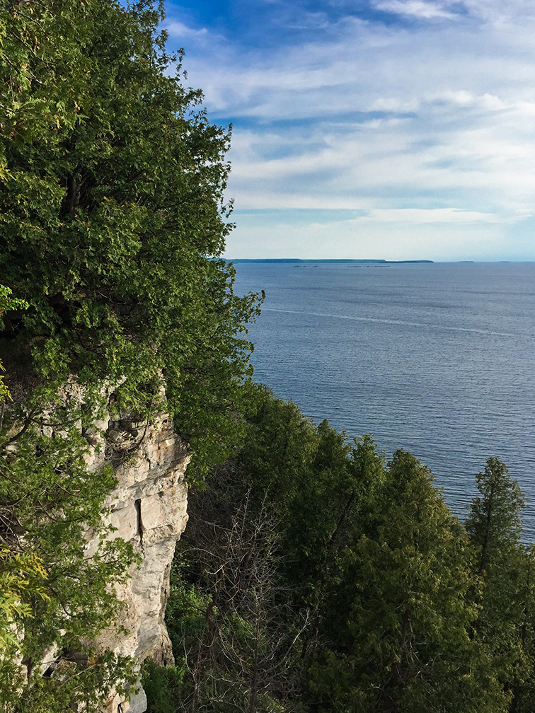 view of green bay and stone cliff