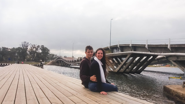 Casal sentando em frente a uma ponte em curvas