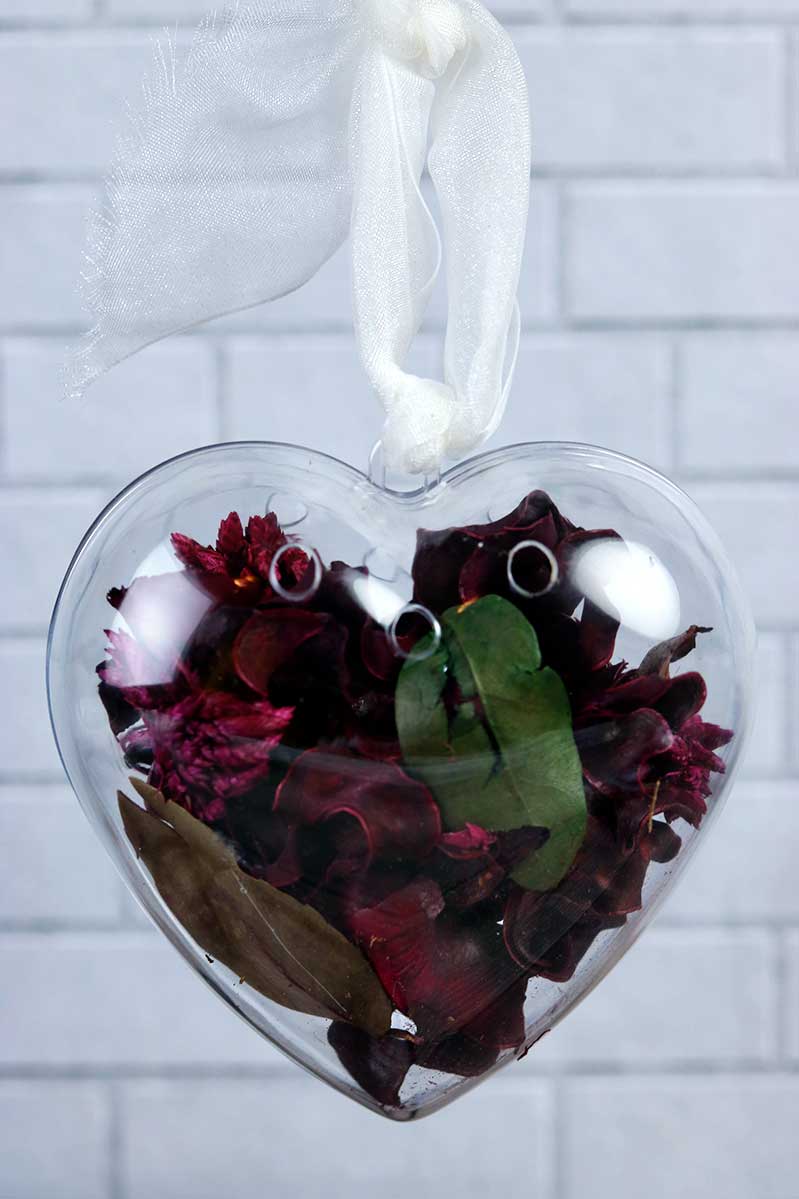 How to make Valentine's Day heart potpourri. This cute crafts for adults uses essential oils for the scent and includes several blend ideas. Make this DIY for gifts or for decorations instead of using sachets or to sell. Use dried flowers and herbs to make easy recipes for homemade potpourri. You could also set it in a bowl instead of using the heart ornaments. #diy #potpourri #essentialoils