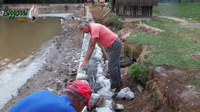 Construção do muro de pedra em volta do lago, com pedra rachão, para evitar o desmoronamento do barranco em volta do lago. Muro de pedra em Cotia-SP.
