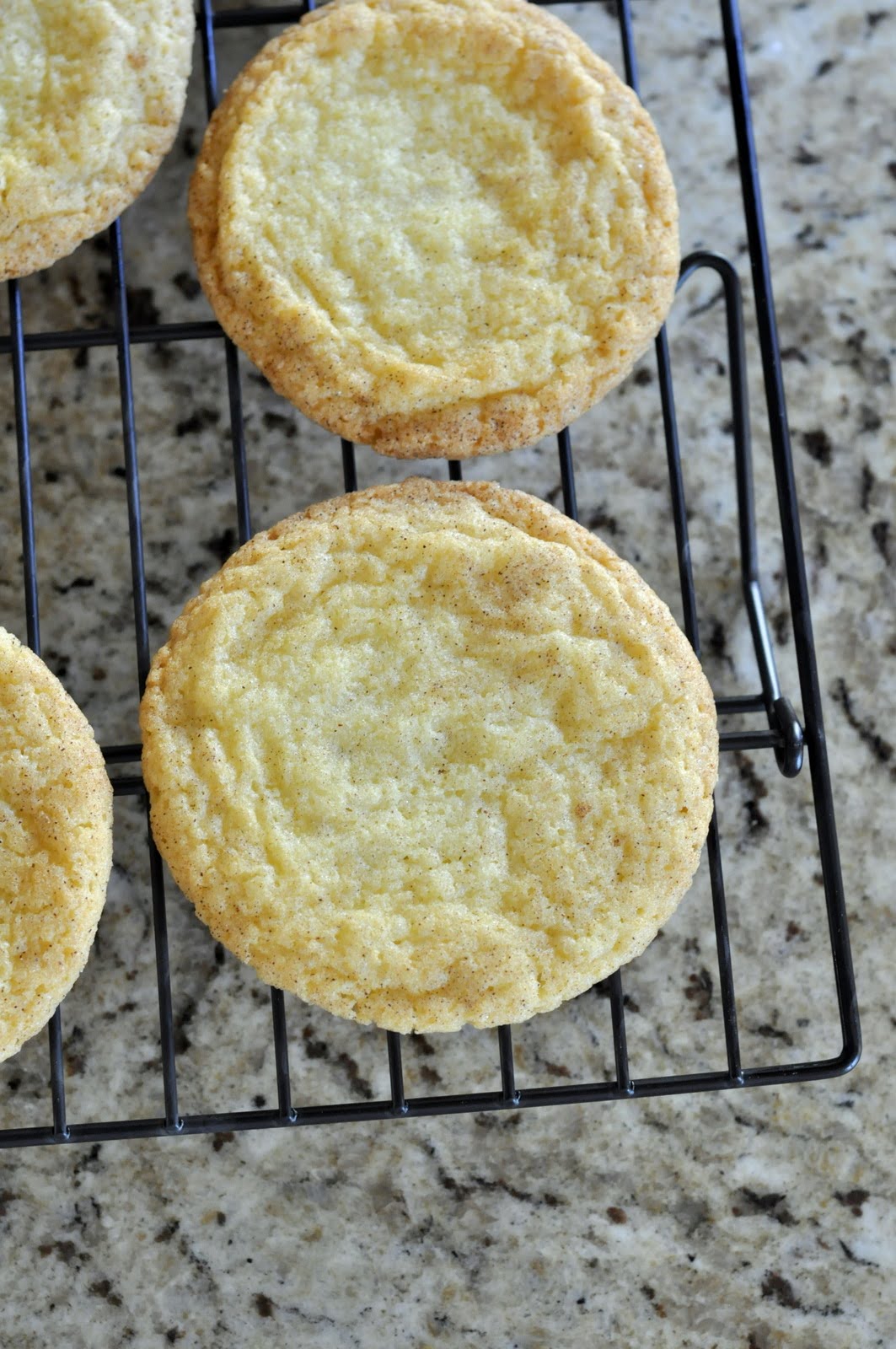 Snickerdoodle cookies cooling on a wire rack. | Taste As You Go