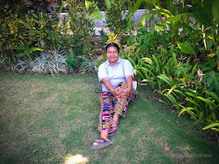 Woman Traveler Sit Back On The Lawn In The Tropical Garden On A Sunny Day At Tangguwisia Village North Bali Indonesia
