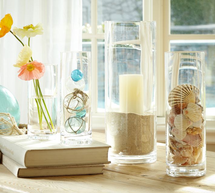 Sand fills a cylinder vase holding a pillar candle