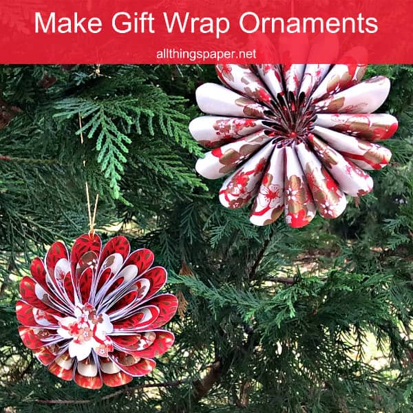 pair of patterned paper Christmas ornaments hanging on evergreen tree