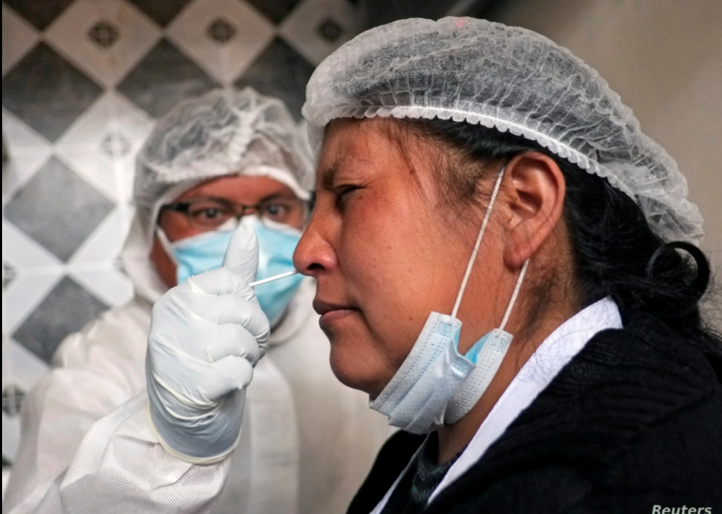 Una trabajadora de la salud le administra un hisopo nasal a una vendedora en un punto de prueba de para detectar COVID-19, en el mercado de Sopocachi en La Paz, Bolivia, el 26 de diciembre de 2020 / REUTERS