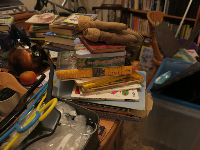 Books on table with kettle, coat hangers and glove