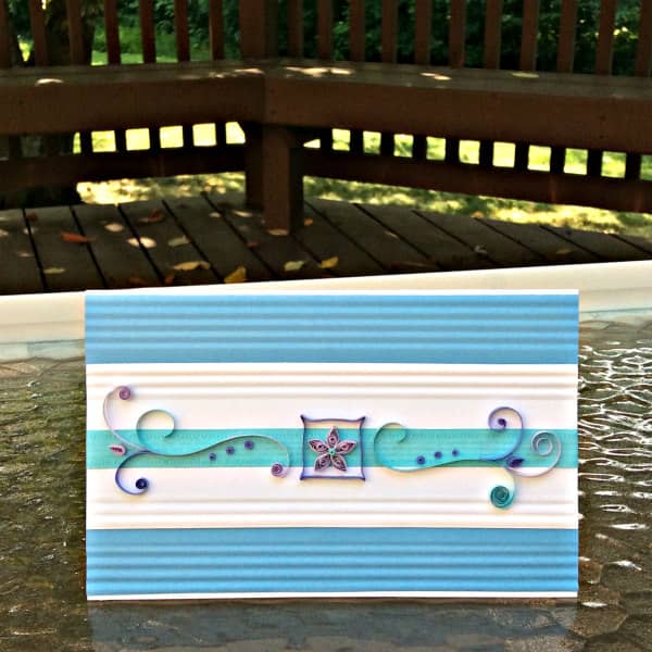 maak een gemakkelijke quilled-kaart voor alle gelegenheden rechthoekige pastelkleurige kaart op glazen buitentafel