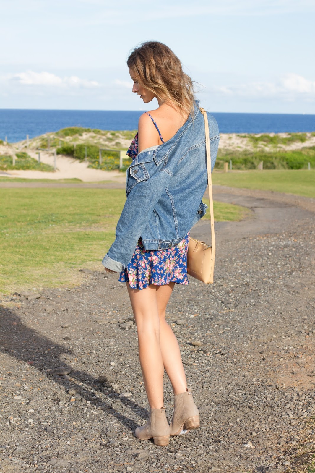 fashion blogger and designer, Alison Hutchinson, is wearing a KAYVALYA blue floral wrap dress, Topshop denim jacket, and Witchery nude suede ankle boots