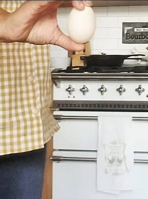 woman holding duck egg in kitchen