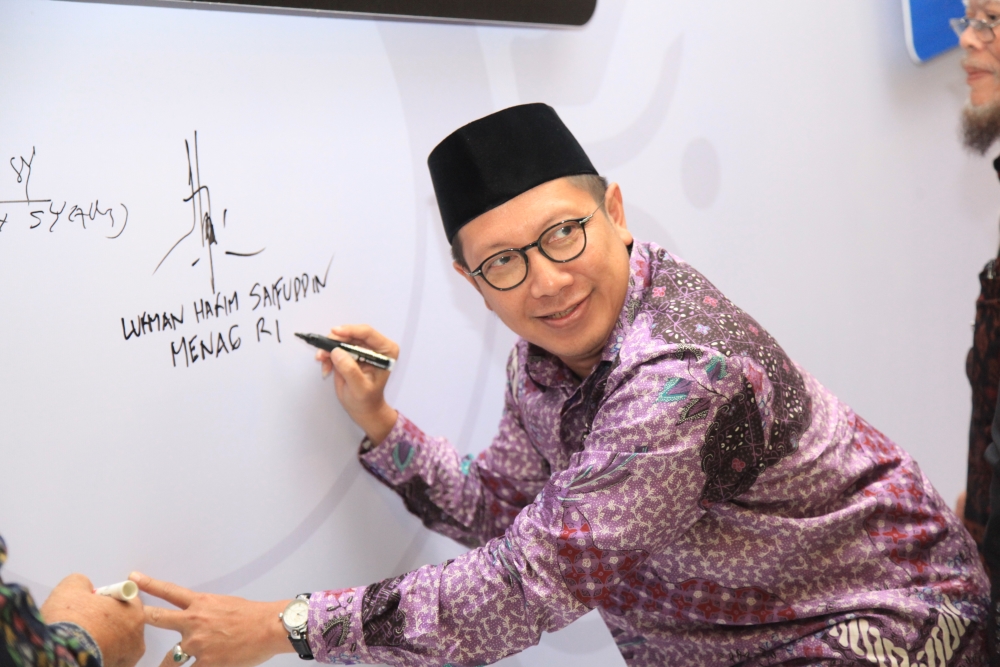 Menteri Agama RI Lukman Hakim Saifuddin membubuhkan tanda tangan pada hari pertama Munas ke-8 LDII di Balai Kartini Jakarta, Selasa (8/11/2016). Foto: LINES