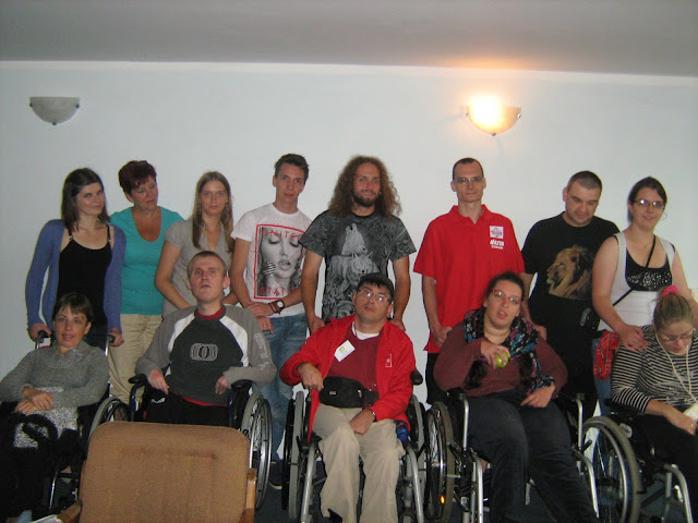 Na zdjęciu widoczni są uczestnicy turnusu w Szczyrku. Stoją w dwóch rzędach, górny rzą to opiekunowie, w dolnym podopieczni na wózkach inwalidzkich.