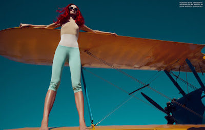 woman on airplane wing, redhead model, neon hair, fashion photographer london