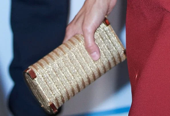 Queen Letizia wore a red midi dress by Roberto Torretta and leather gold sandals by Jimmy Choo. Carolina Herrera gold clutch