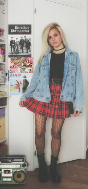 Estilo grunge con camiseta negra, falda de tablas tartán, medias de red grande, botas estilo militar y cazadora vaquera