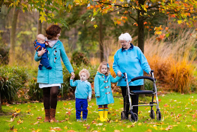 Family walking with rollator in the fall in the grass