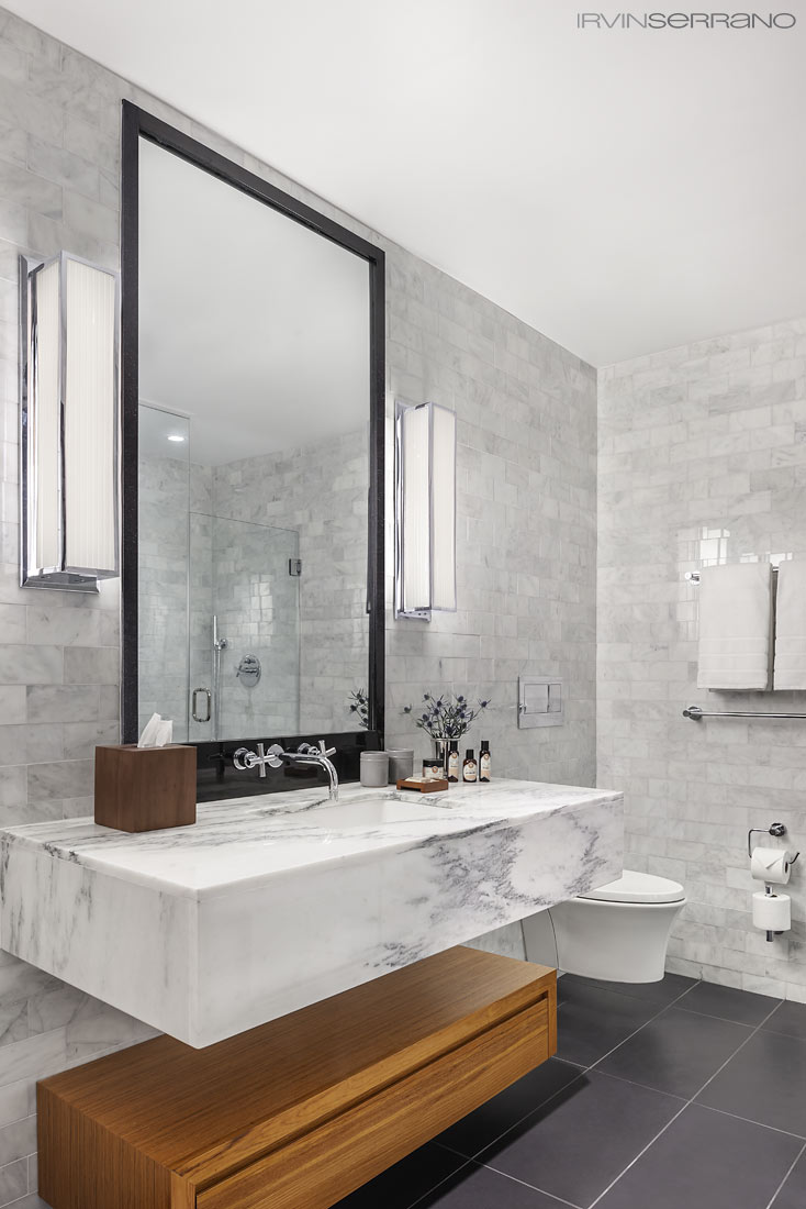 The bathrooms at the Press Hotel in Portland Maine utilize marble and wood accents to create a contemporary and modern design.