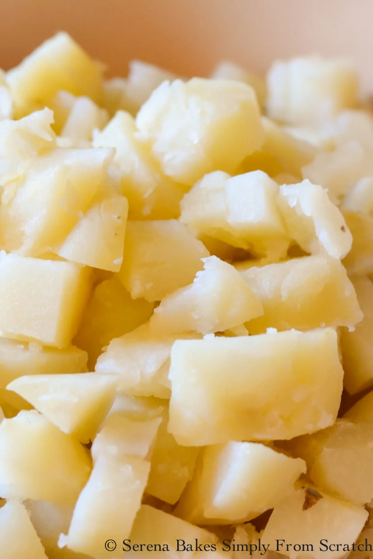 Cooked sliced and peeled potatoes in a bowl for Olive Potato Salad.