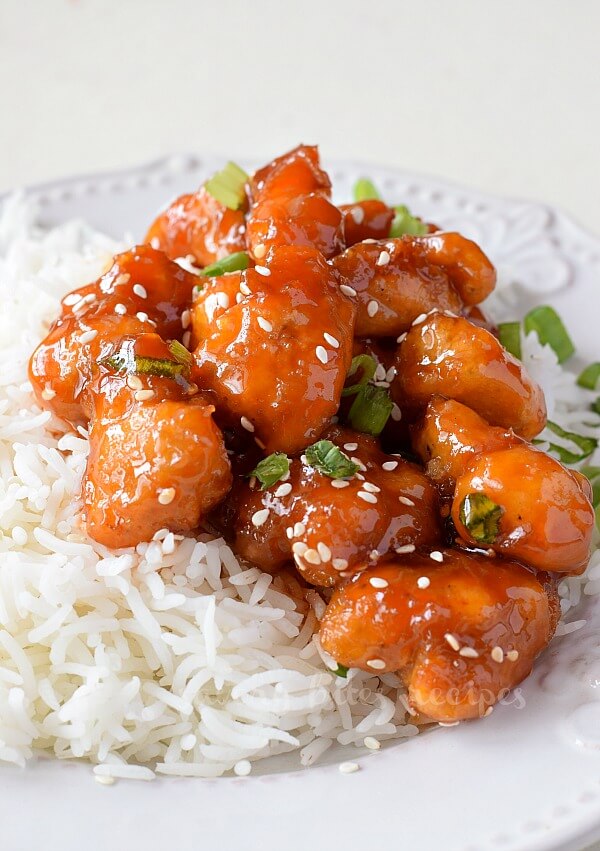 a close look at the crispy sweet and sour chicken served on top of white rice on a plate