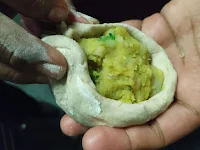 Sealing dough with potato stuffing inside for aloo paratha recipe