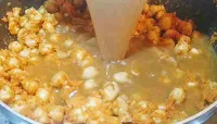 Pouring reserved water for chole chickpeas recipe