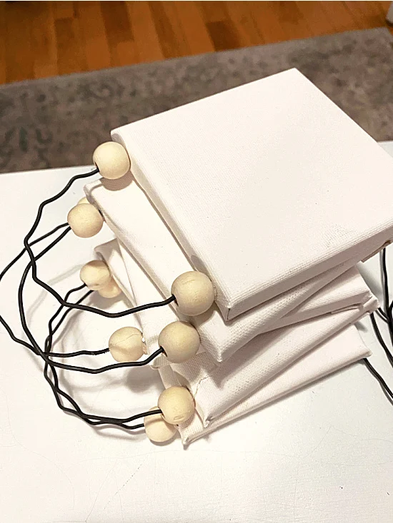 stack of canvases with wires and beads