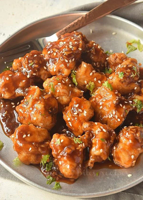 a plate with easy general tsos cauliflower sprinkled with sesame seeds