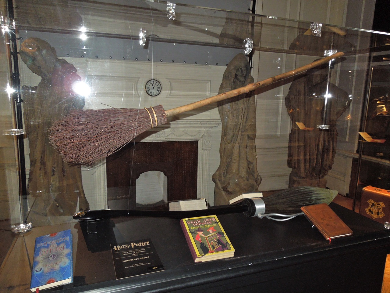 Hollywood Movie Costumes and Props: Hogwarts spell books and broomstick  props from Harry Potter on display