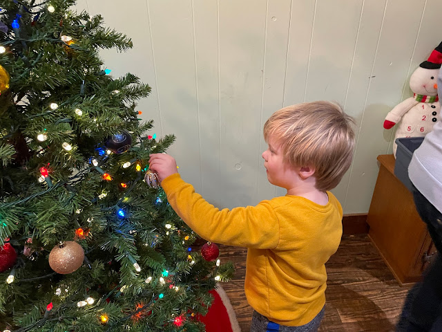 Charlie puts ornaments on our tree