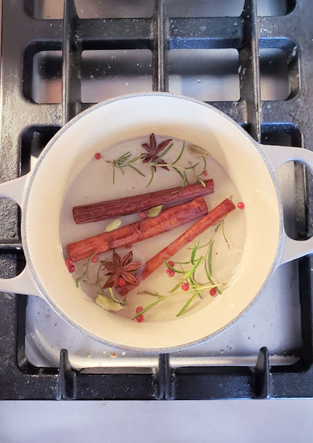 pot on stove with water, cinnamon sticks, star anise