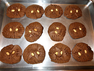 CHOCOLATE AND PEANUT BUTTER COOKIES. PORTIONS: 46 INGREDIENTS 1 cup (2 sticks) butter at room temperature. 1 cup granulated sugar. 1 cup brown sugar. 3 tbsp. Cocoa power 1 cup peanut butter ½ tsp. salt if you use sweet butter. 2 eggs. 2 tsp. vanilla extract. 1½ tsp. baking soda. ¾ tsp. baking powder. 2¾ cups all-purpose flour. ½ cup unsalted peanuts for decoration. DIRECTIONS Preheat the oven at 375° F - 190° C In a bowl mix flour, baking soda, baking powder , salt if needed. In a mixing bowl beat butter, granulated sugar and brown sugar until creamy. Mix in the cocoa powder. Add and mix the peanut butter.  Add and beat in the mix the eggs and vanilla extract. Incorporate the flour mix and beat it in. Roll the dough in parchment paper, about 2 inches in diameter and cut it in 2” pieces. Place the slices of dough in a greased sheet pan. With a fork mark some lines for decoration. Place a few peanuts on top of the cookies dough. Bake for about 10 - 12 minutes. Do not overcook cookies, because they will become hard. The dough can be rolled in parchment paper and freeze for next time. You can use half of the dough and freeze the rest.