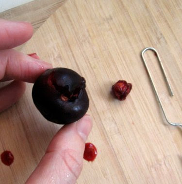 pitting a cherry with a paper clip