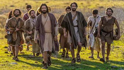 Jesus walking through a field with his disciples.