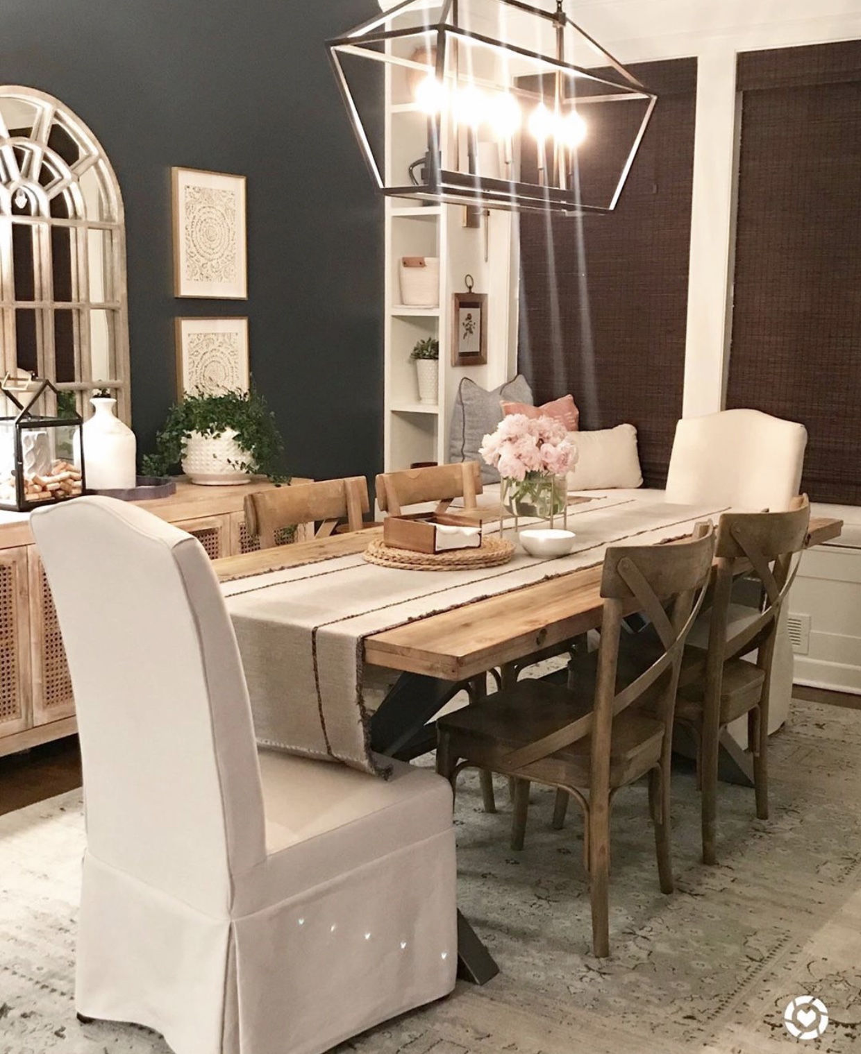 Dark blue walls dining area with built in shelves and window seat