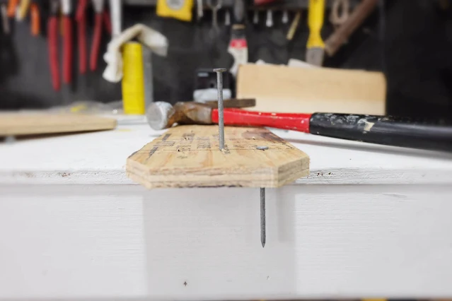 pounding nails through plywood sole
