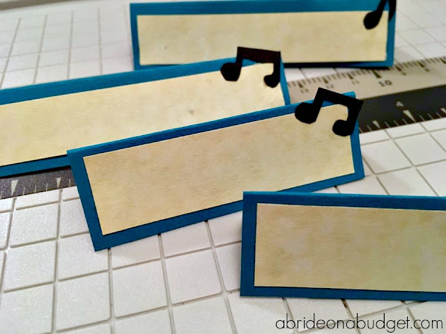 Add a little music to your wedding reception with these DIY Music Note Escort Cards. Find out how to make them on www.abrideonabudget.com.