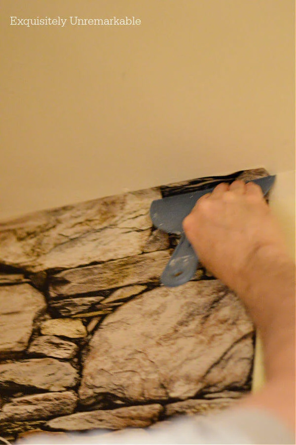 Using a scraper to smooth wallpaper
