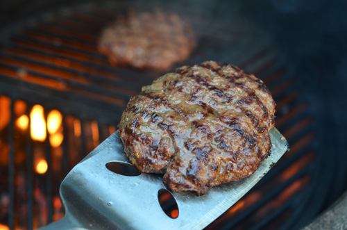 Burger coming off of the grill.