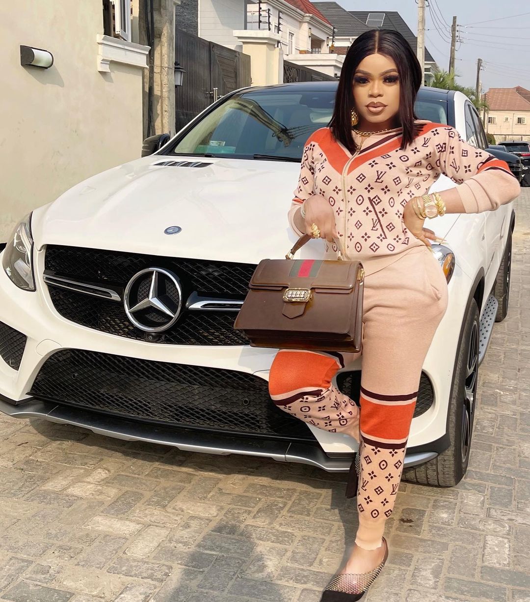 Bobrisky poses with his car