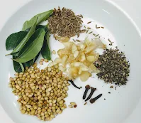 Coriander seeds,cumin, cloves, curry leaves, garlic for chicken ghee roast recipe