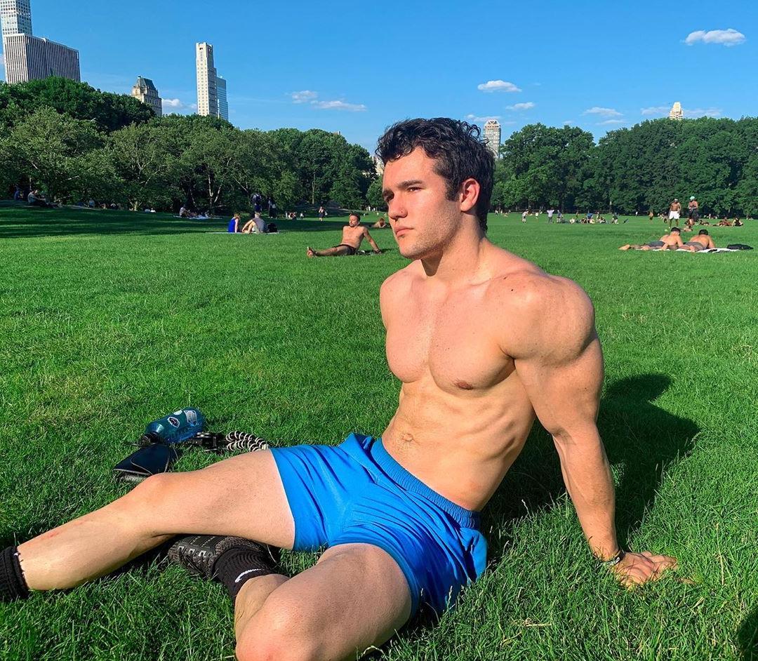cute-college-teen-shirtless-fit-bro-chilling-grass-field-blue-shorts