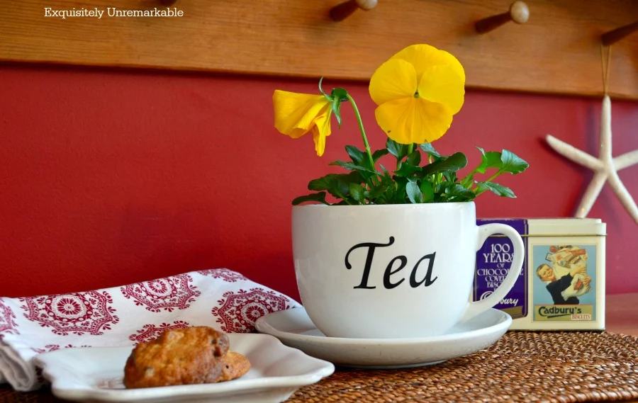 Pansies planted in a tea cup on a kitchen breakfront