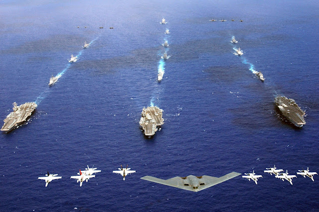 A B-2 Spirit and 16 other aircraft from the Air Force, Navy and Marine Corps fly over the USS Kitty Hawk, USS Ronald Reagan and USS Abraham Lincoln carrier strike groups 