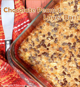 Chocolate Peanut Layer Bars start with chocolate graham cracker crust and are layered with candy bits, dark chocolate chips, peanuts and more. Simple to make, addicting to eat. | Recipe developed by www.BakingInATornad.com | #recipe #bake 