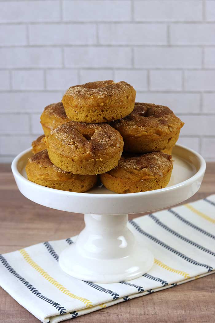 How to make delicious pumpkin doughnuts. How to make donuts from scratch. This quick homemade fall dessert is great for kids! Make a soft doughnut recipe that's baked in the oven. This easy cake like donut recipe is simple and fast to make.  Roll the doughnuts in melted butter and cinnamon sugar for more flavor.  #doughnut #pumpkin #pumpkindoughnut 
