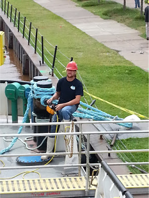 A crew member works the control of the crane