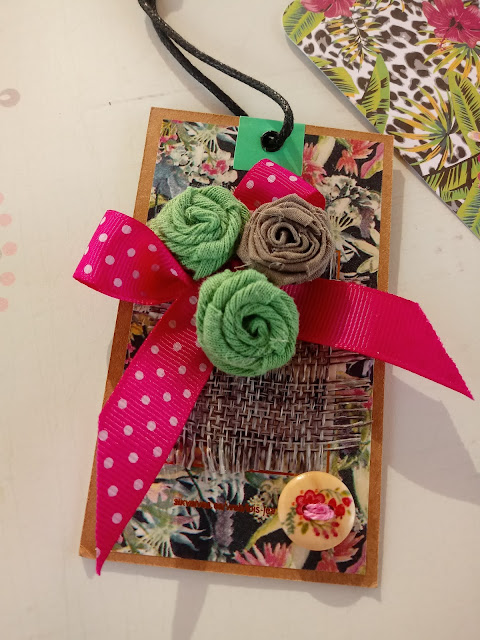 Etiqueta colgante decorada con cinta de regalo, botones y trocitos de tela de saco o similar