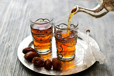 Source: Westin Jakarta website. Tea poured into glasses with dates by the side.