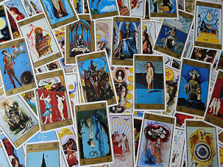 Imagen de todas las cartas del tarot revueltas sobre una mesa